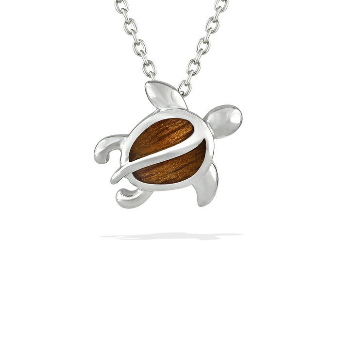 Small honu pendant with koa wood inlay, featuring a polished sea turtle design natural wood grain. Item No. 770261